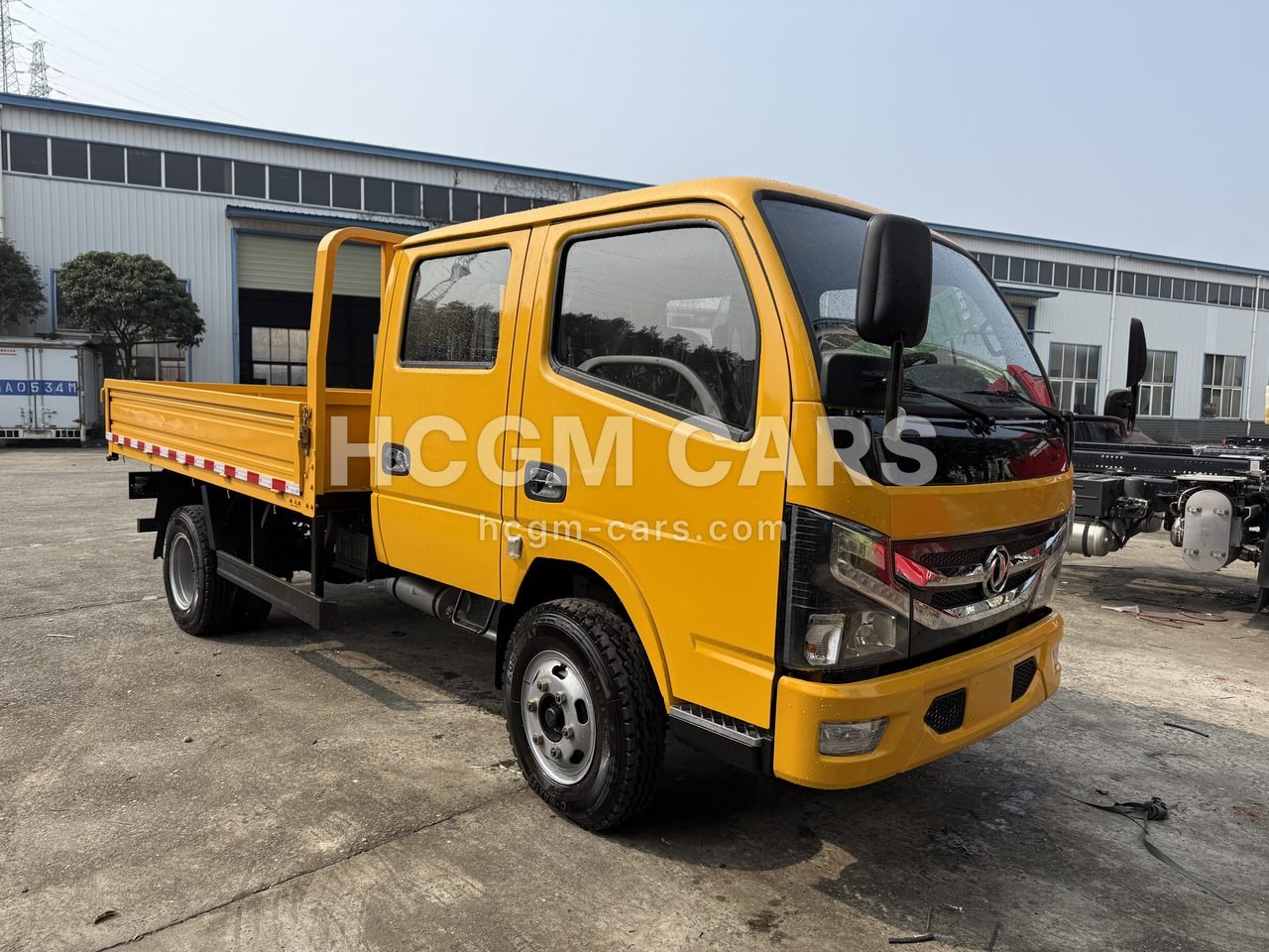 Yellow Dongfeng double-cab cargo truck, front three-quarter view from the right