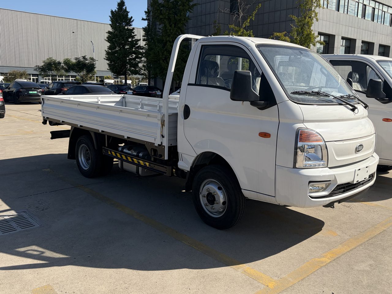 KAMA 2.8L diesel light truck in white with dropside bed, front three-quarter view